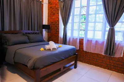 a bedroom with a bed with towels and flowers on it at DAWA Brickhouse - Balinese Guesthouse in Thompson Ipoh by Ryokan Management in Ipoh