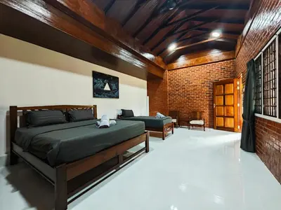 a bedroom with a bed and a brick wall at DAWA Brickhouse - Balinese Guesthouse in Thompson Ipoh by Ryokan Management in Ipoh