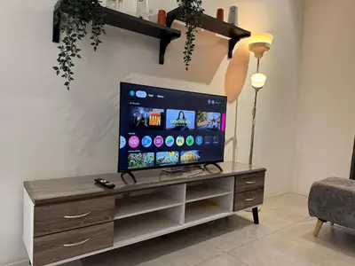 a living room with a flat screen tv on a wooden entertainment center at Simple Stay Aston Acacia Bukit Mertajam in Bukit Mertajam