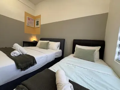 a room with two beds and a chair in it at Simple Stay Aston Acacia Bukit Mertajam in Bukit Mertajam
