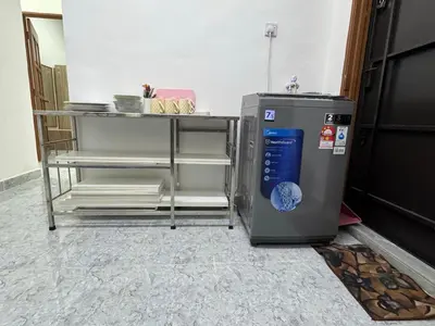 a small refrigerator next to a table in a room at Cozy 4BR Homestay with 2 Baths Taman Seraya in Kulim