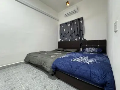 a bedroom with a bed with a blue comforter at Cozy 4BR Homestay with 2 Baths Taman Seraya in Kulim