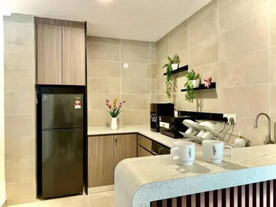 a kitchen with a black refrigerator and a counter at ICC Luxury Suites by Grab A Stay in Ipoh