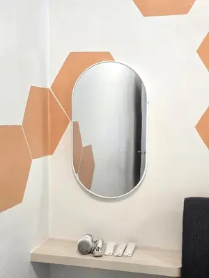 a mirror on a wall with two remote controls at The Highland Hive in Tanah Rata