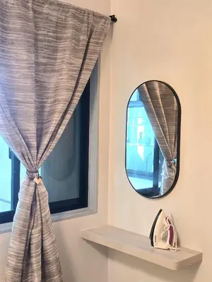 a mirror and a window with a curtain at The Highland Hive in Tanah Rata
