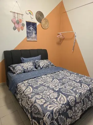 a bedroom with a bed with a blue and white comforter at The Highland Hive in Tanah Rata