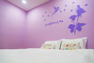 a bedroom with a bed with flowers and butterflies on the wall at Lavender Home in Sekincan