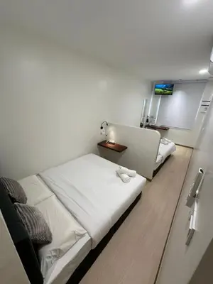 a room with two beds and a desk in it at LM Motel in Kulim