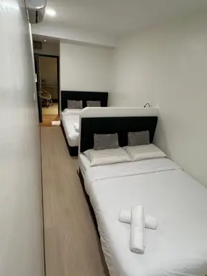 two beds in a room with white sheets at LM Motel in Kulim