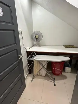 a room with a desk with a fan and a door at LM Motel in Kulim
