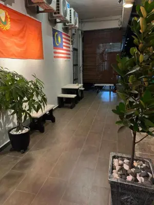 an empty room with benches and plants and an american flag at LM Motel in Kulim
