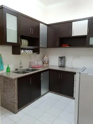 a kitchen with dark brown cabinets and a sink at SRS WIN Homestay BPJ in Sungai Petani