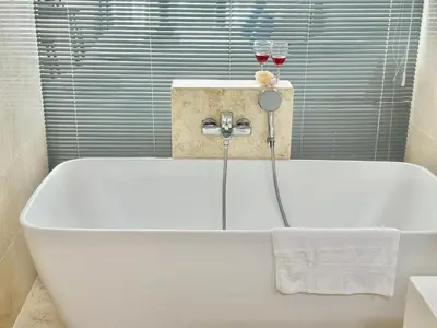 a white bath tub with two glasses of wine at New Reno Jazz Suite 2 bedroomsSeaviewKaraoke in Tanjong Tokong