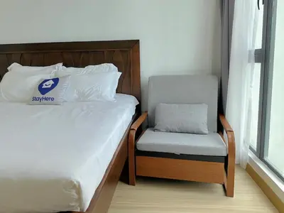a bed and a chair in a small room at New Reno Jazz Suite 2 bedroomsSeaviewKaraoke in Tanjong Tokong
