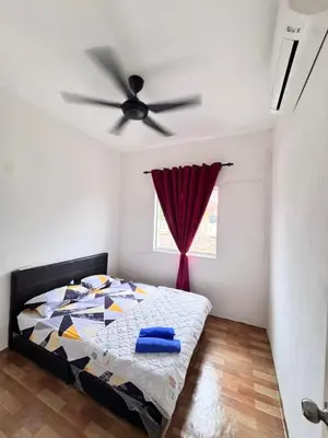 a bedroom with a bed and a ceiling fan at Homestay Tanah Liat in Bukit Mertajam