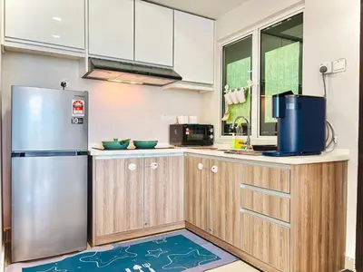 a kitchen with wooden cabinets and a stainless steel refrigerator at Majestic Condo Ipoh Central by PLY Home in Ipoh