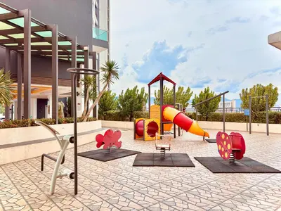 a playground with colorful playground equipment in front of a building at Majestic Condo Ipoh Central by PLY Home in Ipoh