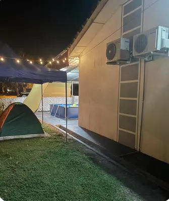 a tent is set up next to a building at Aileen Homestay Swimming Pool in Batu Gajah