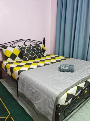 a bedroom with a bed with yellow and black pillows at Aileen Homestay Swimming Pool in Batu Gajah