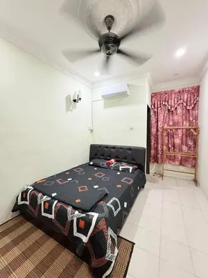 a bedroom with a bed and a ceiling fan at Ulie Empire Homestay in Sungai Petani