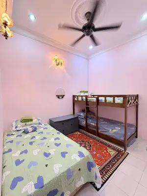 a bedroom with a bed and a ceiling fan at Ulie Empire Homestay in Sungai Petani