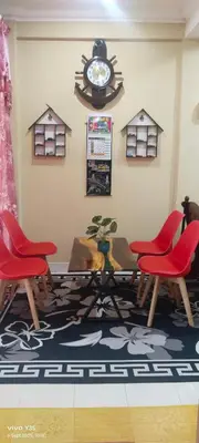 a room with chairs and a table and a clock at Ulie Empire Homestay in Sungai Petani
