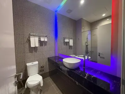 a bathroom with a toilet and a sink with a purple light at Hotel Warisan in Taiping