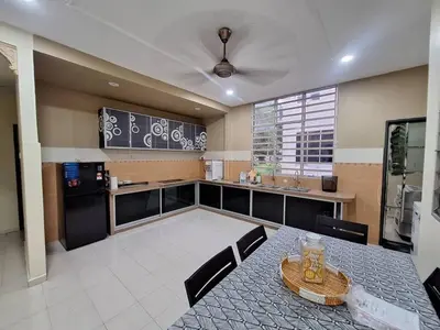 a kitchen with a table and chairs and a counter at LB Homestay in Lunas