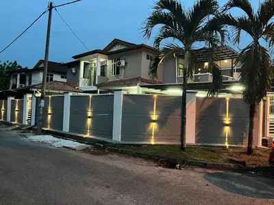 a white fence in front of a house with lights at LB Homestay in Lunas