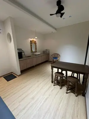a living room with a table and a bathroom at LM Homestay in Kulim