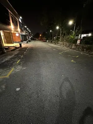 an empty street at night with lights on at LM Homestay in Kulim