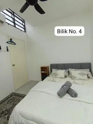 a bedroom with a white bed with a ceiling fan at Homestay AinulZahra- For Malays Only in Seri Iskandar