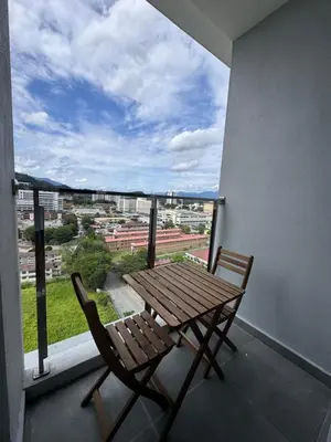 a wooden table and chairs on a balcony with a view at ICC Suites Ipoh City Centre Walking Distance to Shopping Mall in Ipoh
