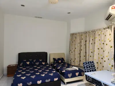 a bedroom with two beds and a desk and a table at GHome Cheerful comfort home in Butterworth