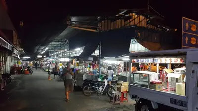 a group of people walking through a market at night at GHome Cheerful comfort home in Butterworth