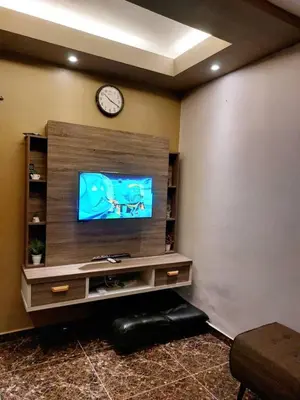 a living room with a tv and a clock on the wall at fz north silibin in Ipoh