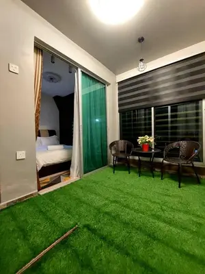 a living room with green grass and a bedroom at fz north silibin in Ipoh