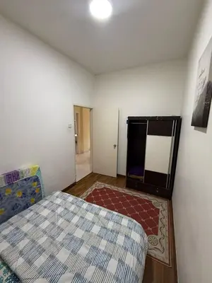 a bedroom with a bed and a room with a rug at Cameron Prima Villa Homestay in Tanah Rata