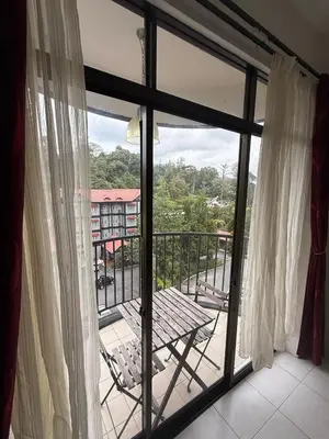 a balcony with a table and a view of a building at Cameron Prima Villa Homestay in Tanah Rata