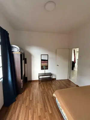 a bedroom with a bed and a bench in a room at Cameron Prima Villa Homestay in Tanah Rata