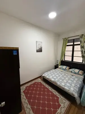 a bedroom with a bed and a window and a rug at Cameron Prima Villa Homestay in Tanah Rata