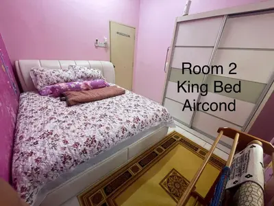 a bedroom with a bed with a pink room king bed ahead at ZzHomestay