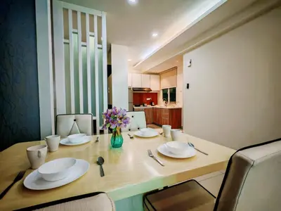 a dining room table with plates and a vase of flowers at Ipoh Majestic Modern City 2BR Condo - Food Street in Ipoh