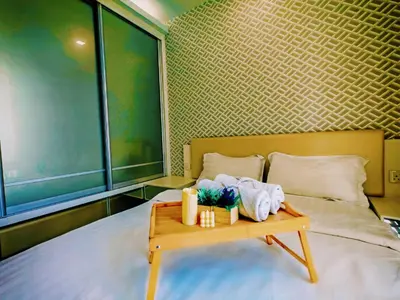 a bedroom with a bed with a table with towels on it at Ipoh Majestic Modern City 2BR Condo - Food Street in Ipoh
