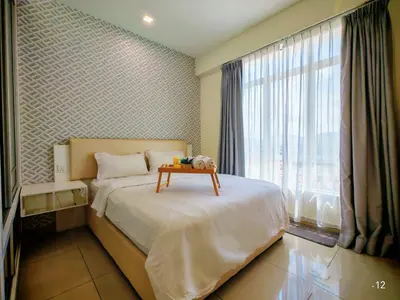 a bedroom with a bed with a table on it at Ipoh Majestic Modern City 2BR Condo - Food Street in Ipoh