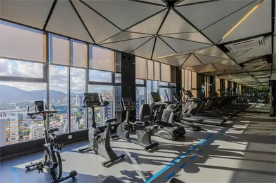 a gym with a row of treadmills and exercise bikes at SkyPool at 22Macalisterz - Georgetown City Centre, 4pax by PG Home in George Town