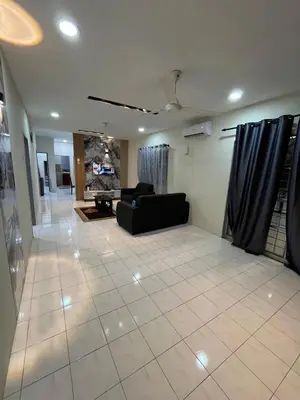 a living room with a black couch and a tile floor at KMK Homestay in Sungai Petani