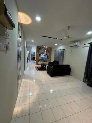 a living room with a black couch and a tile floor at KMK Homestay in Sungai Petani