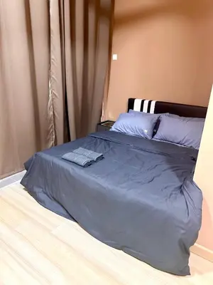 a bed with a blue blanket on top of it at MU Homestay in Simpang Ampat