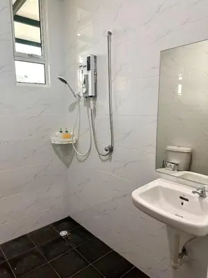 a white bathroom with a shower and a sink at MU Homestay in Simpang Ampat